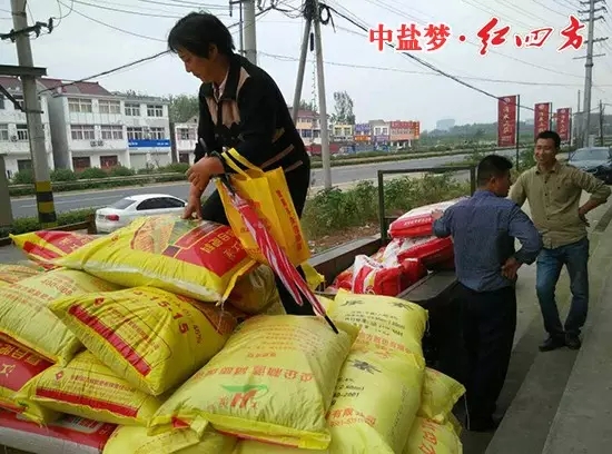 農戶拿著紅四方贈送的小禮品，樂滋滋地開著裝滿紅四方肥料的拖拉機準備回家